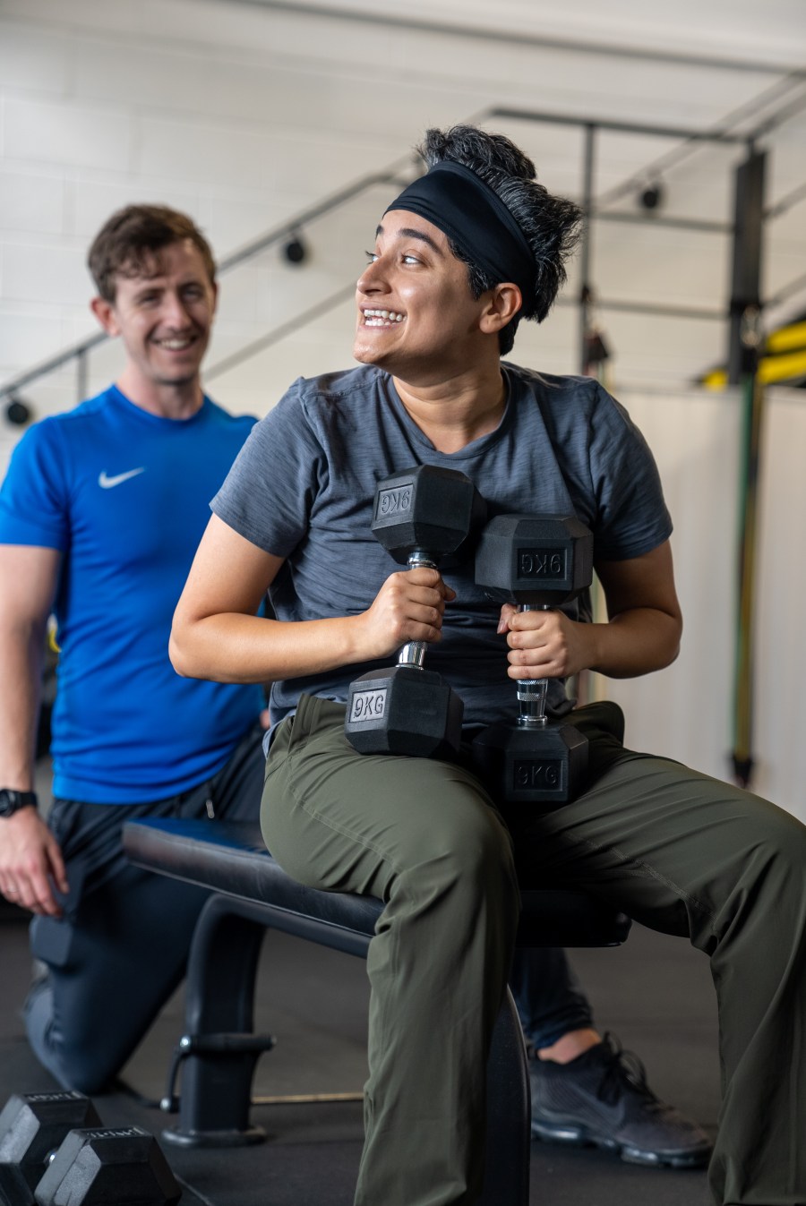 Timmo supporting a client during a dumbbell strength exercise
