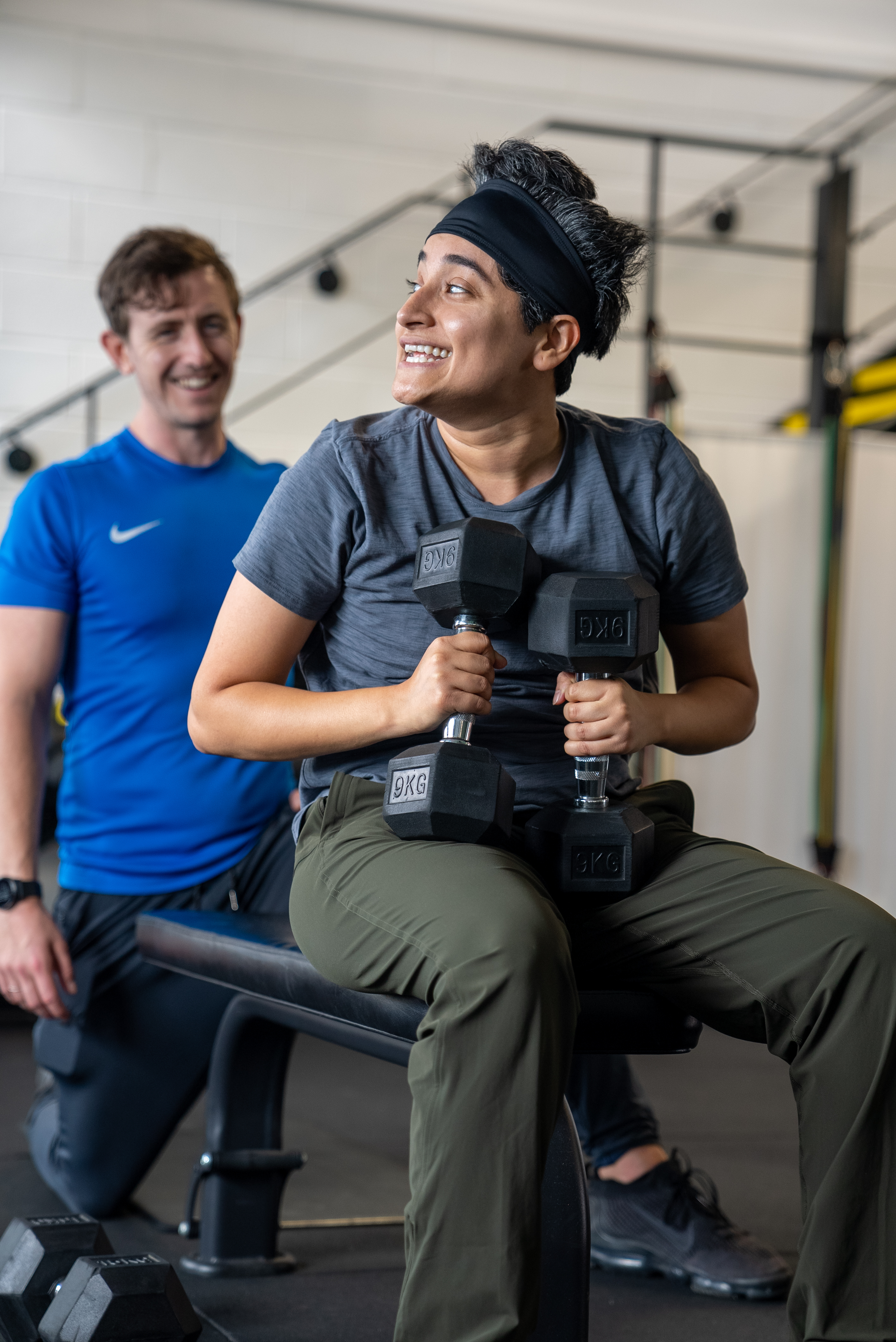Timmo supporting a client during a dumbbell strength exercise